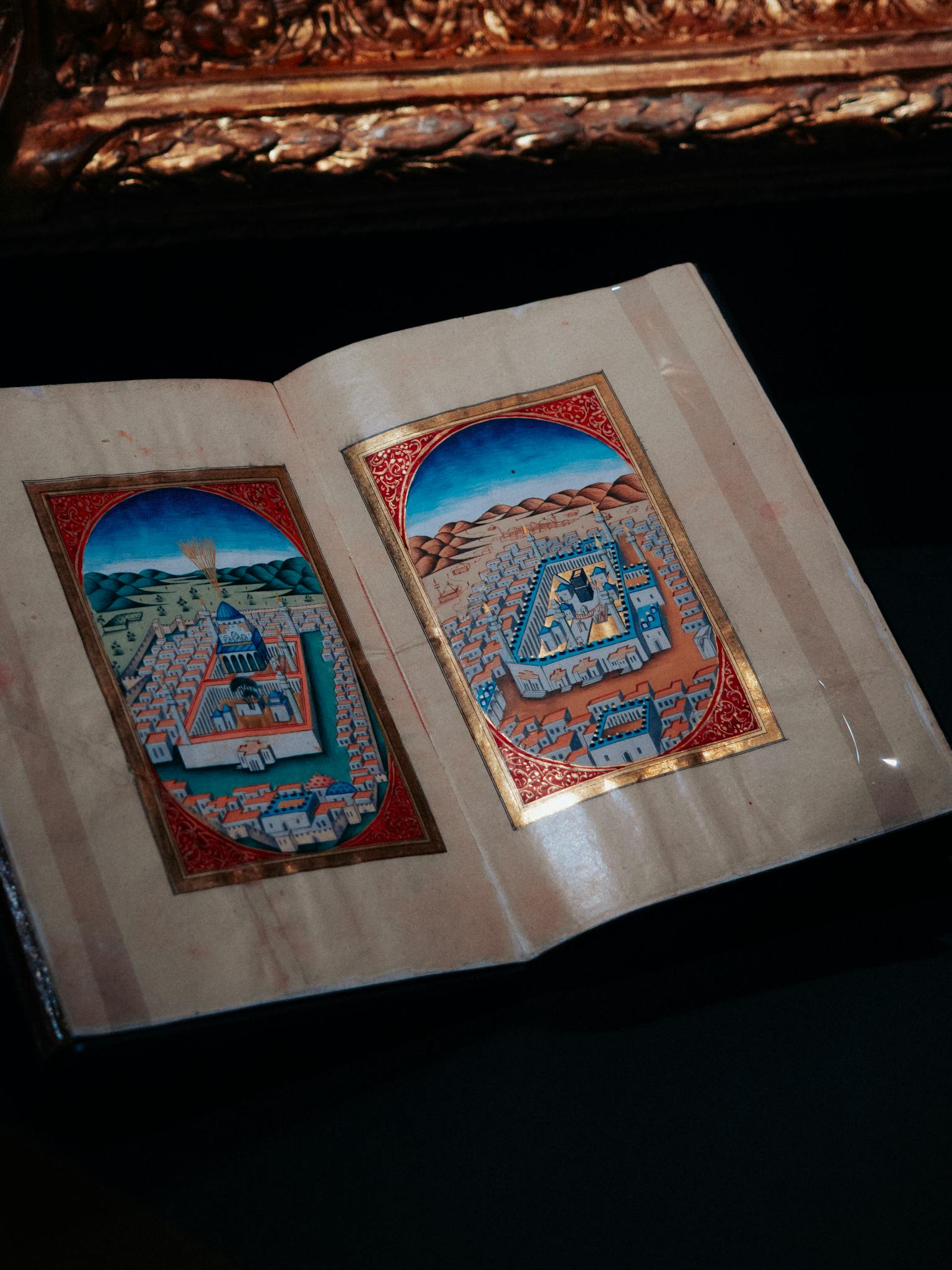 Detailed photo of an ancient manuscript with medieval illustrations of historical towns.